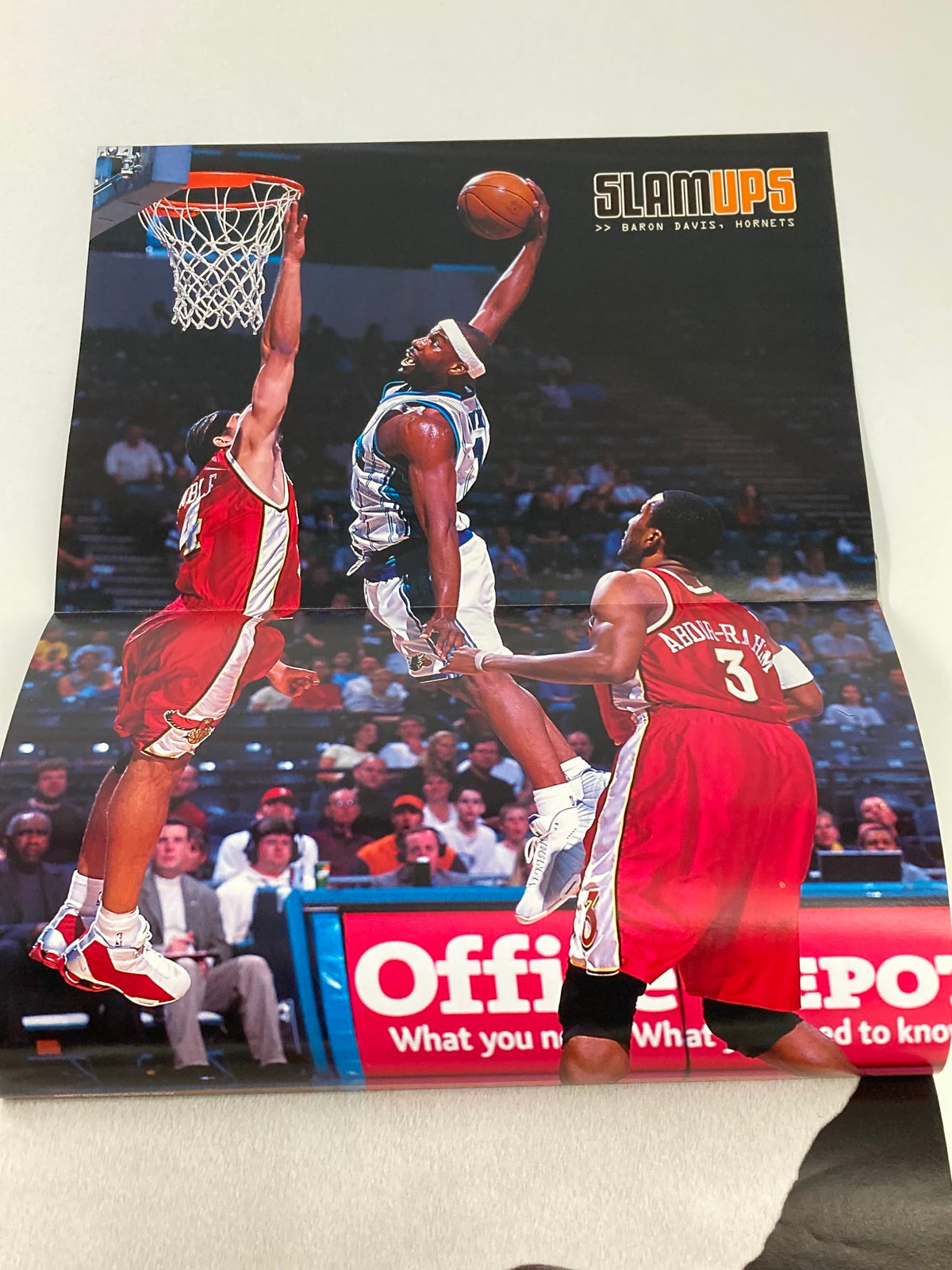 Slam Magazine August 2002 featuring a poster of an action-packed basketball scene with players in mid-air, showcasing athleticism and excitement, part of the LeBron James and Sebastian Telfair edition.