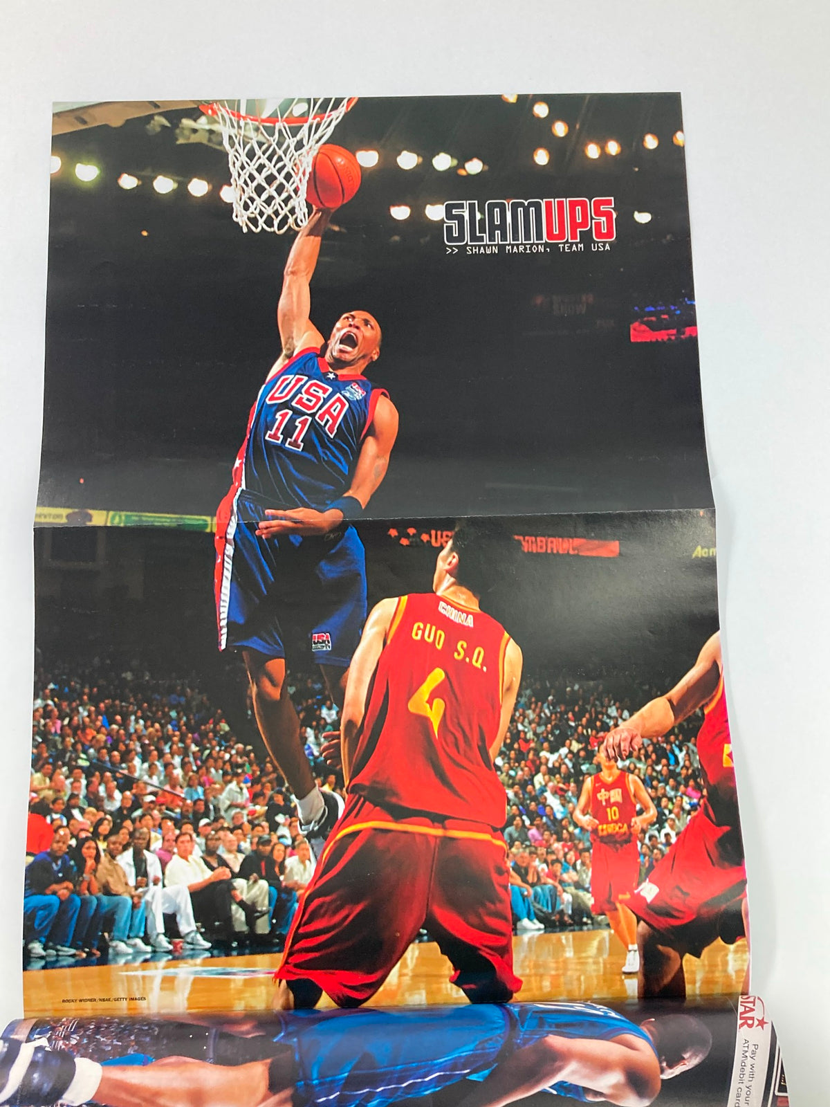 Poster from Slam Magazine November 2002 depicting a USA basketball player making a stunning dunk during a game, highlighted under the 'SLAMUPS' section.
