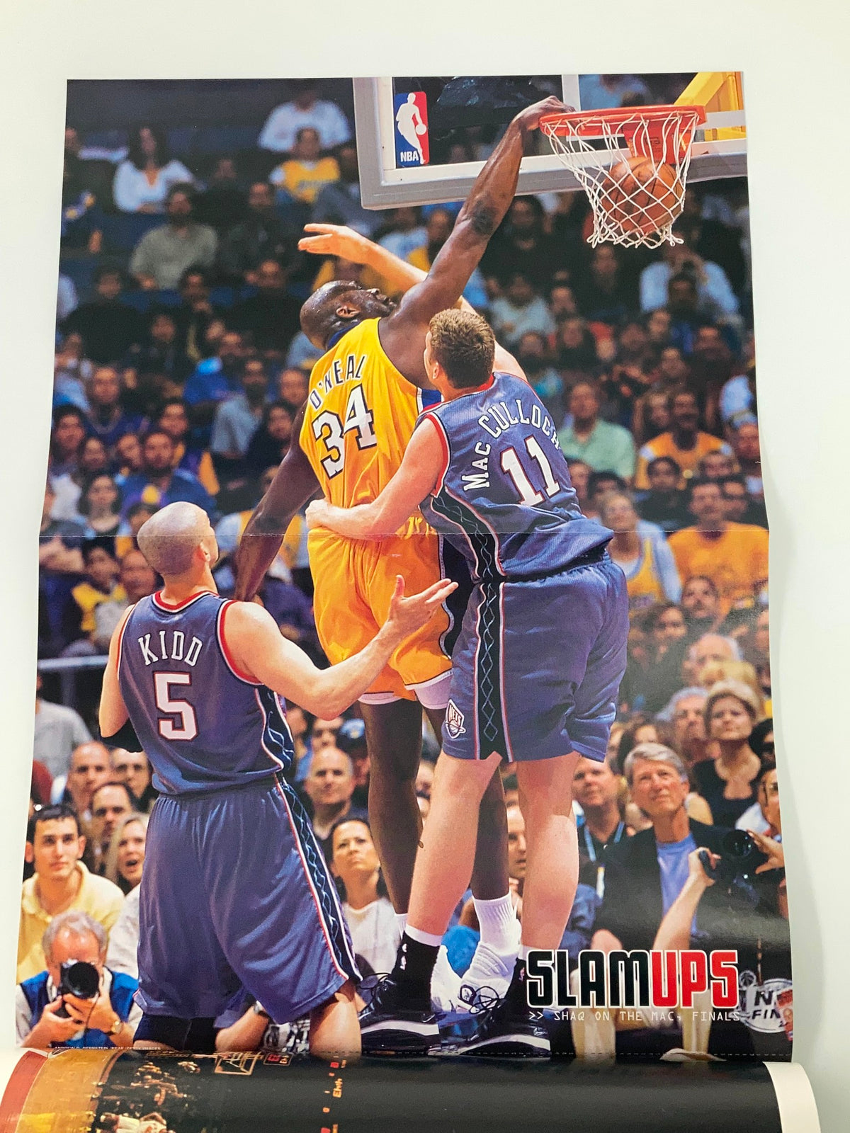 Poster from Slam Magazine September 2002 featuring Shaquille O'Neal performing a slam dunk against opponents, capturing a memorable moment from the 2002 NBA season.