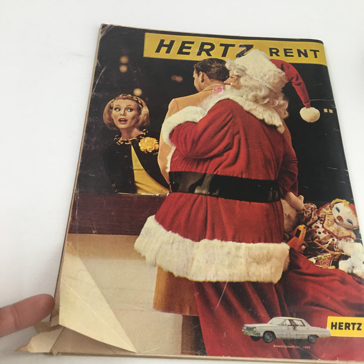 Front cover of Sports Illustrated Magazine December 16 1963 featuring Santa Claus and a woman at a rental car desk, highlighting its Christmas theme.