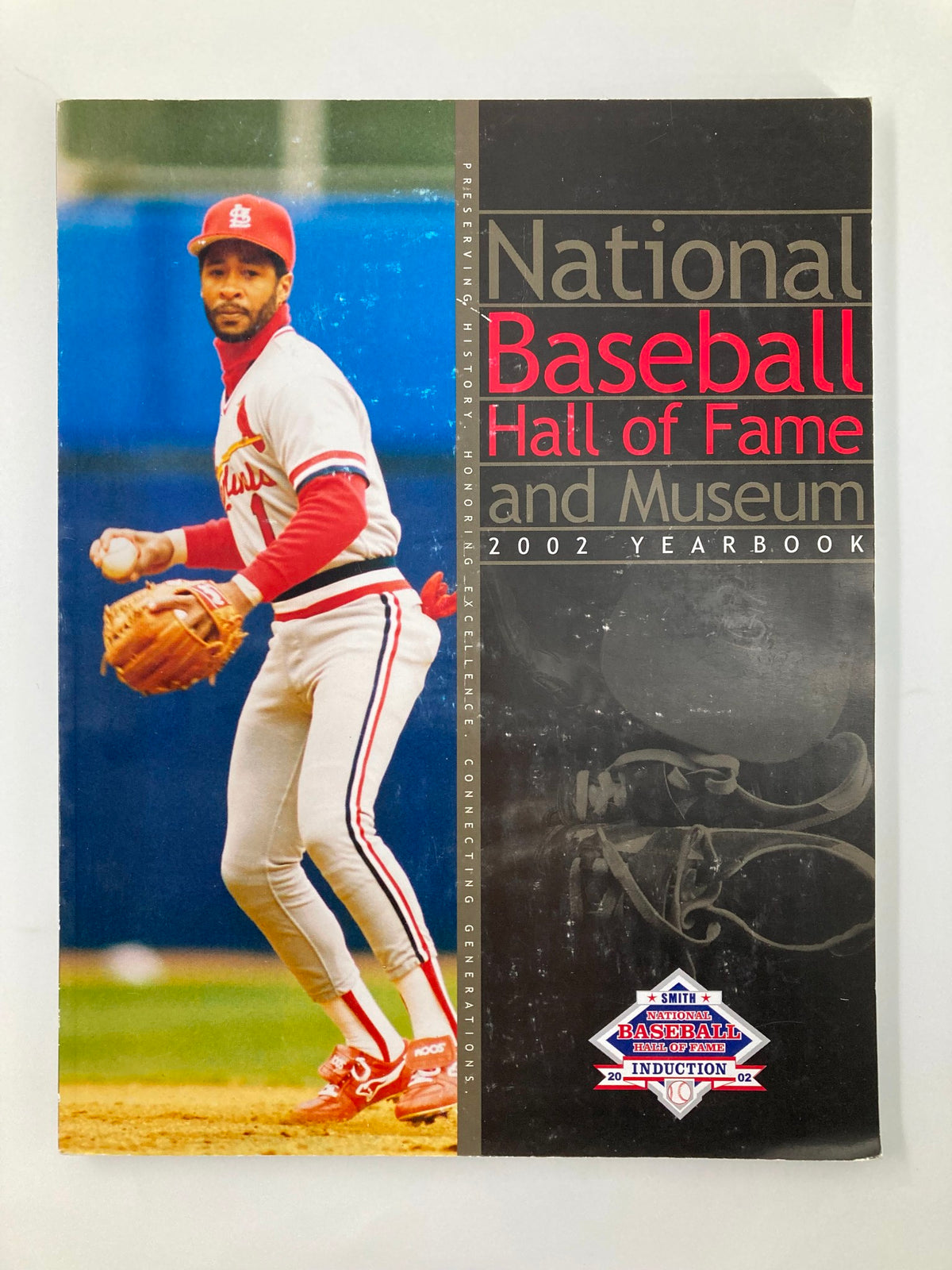 2002 National Baseball Hall of Fame and Museum Yearbook featuring Ozzie Smith on the cover, showcasing a baseball player in a red and white uniform during a game.