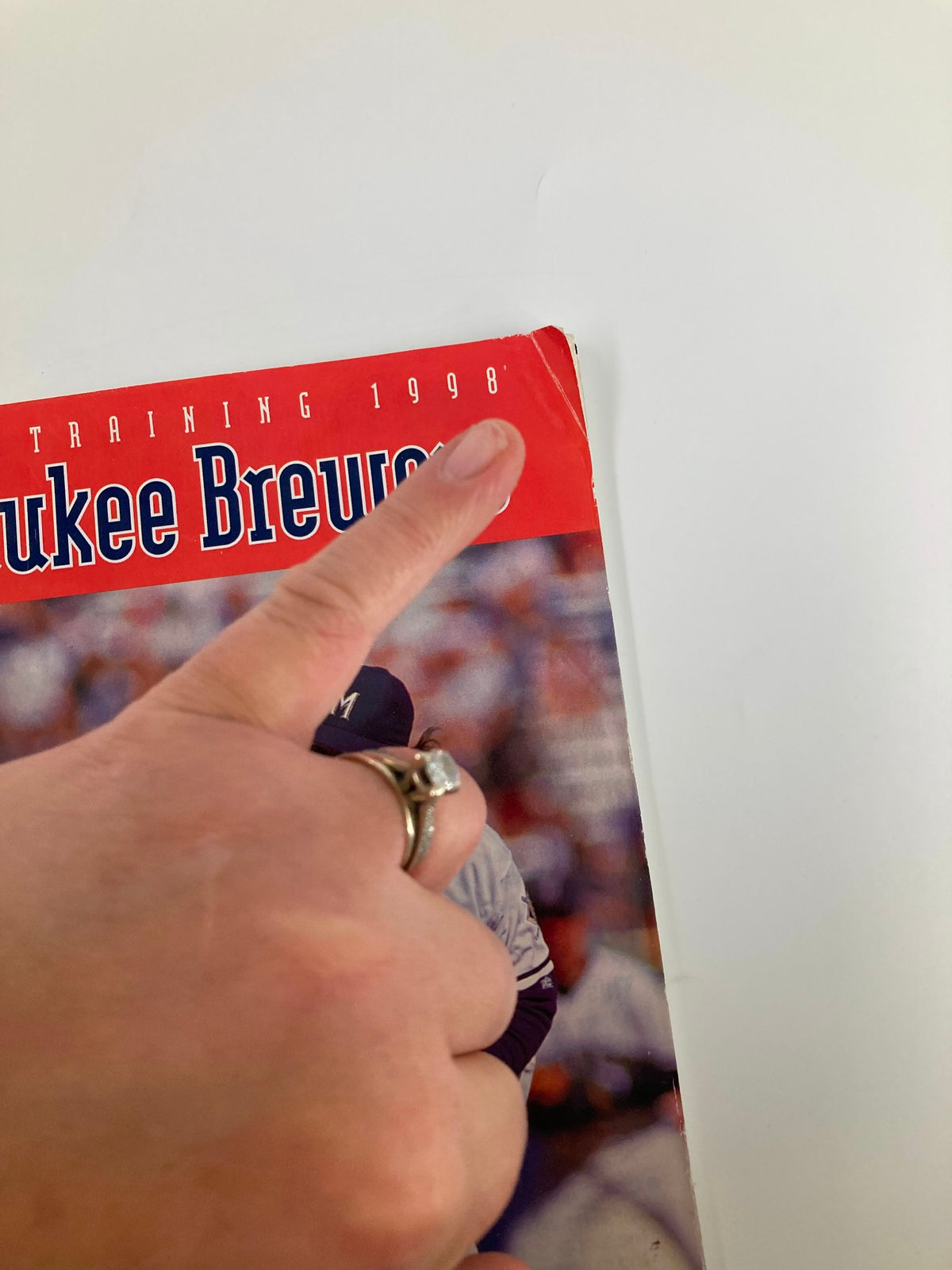 Close-up of the 1998 MLB Milwaukee Brewers Official Spring Training Program with a focus on the top corner, emphasizing the prominent year and condition of the cover.