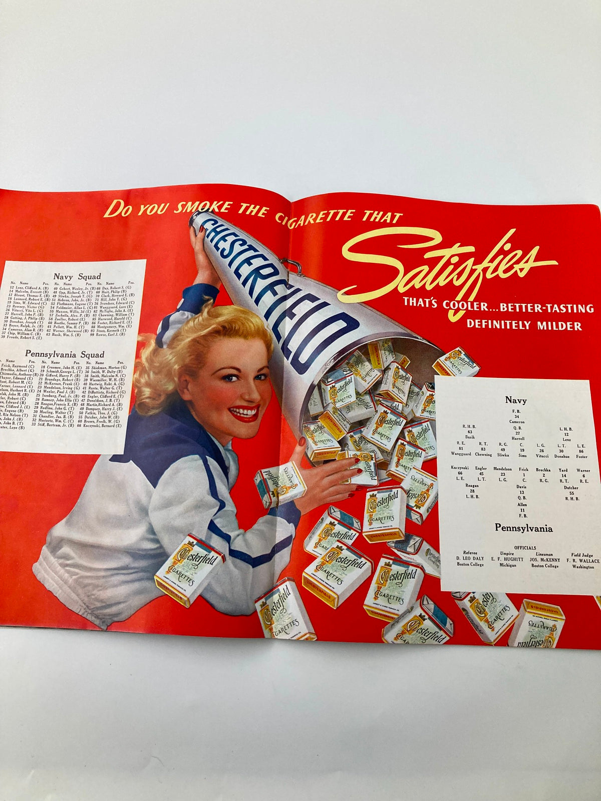 Vintage advertisement from the 1940 NCAA Football Navy vs Pennsylvania Official Statistics Program, showcasing a marketing piece featuring a blonde woman promoting a cigarette brand.