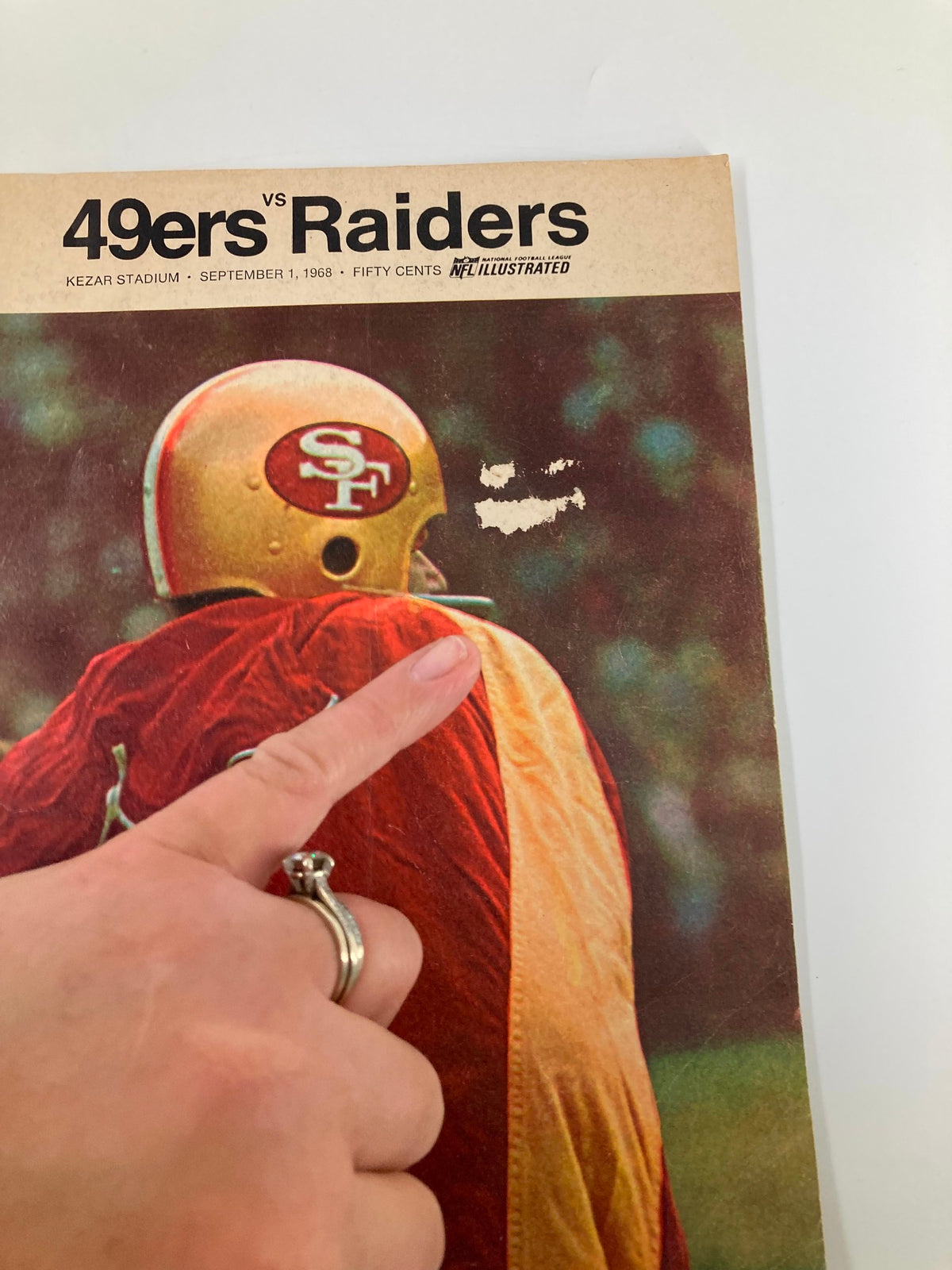 Cover of the 1968 NFL Illustrated Las Vegas Raiders vs San Francisco 49ers Official Program, featuring a San Francisco 49ers player wearing a gold helmet with an SF logo.