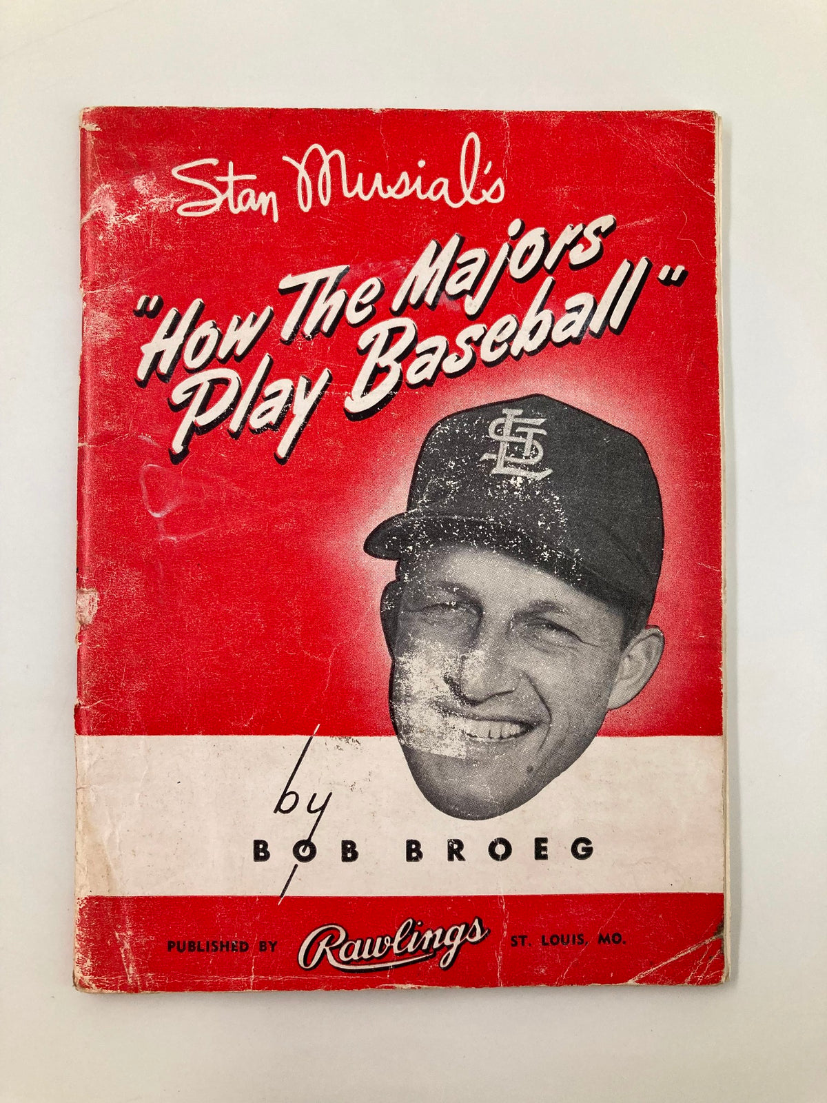 Cover of 'Stan Musial's How The Majors Play Baseball' by Bob Broeg featuring a photo of Stan Musial and a red design.