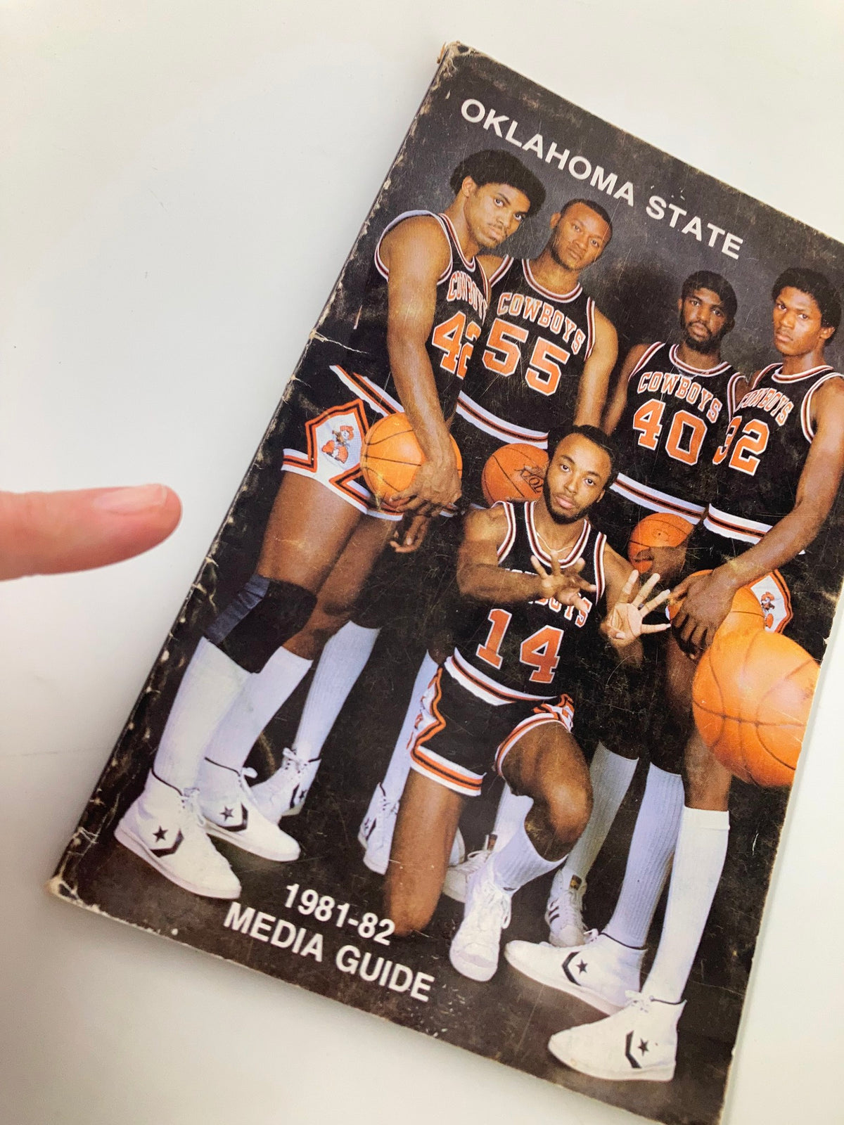 1981-1982 NCAA Basketball Oklahoma State University Cowboys Media Guide featuring a team photo of five players in uniforms, showcasing athletic poses and basketballs, highlighting the school's basketball heritage.