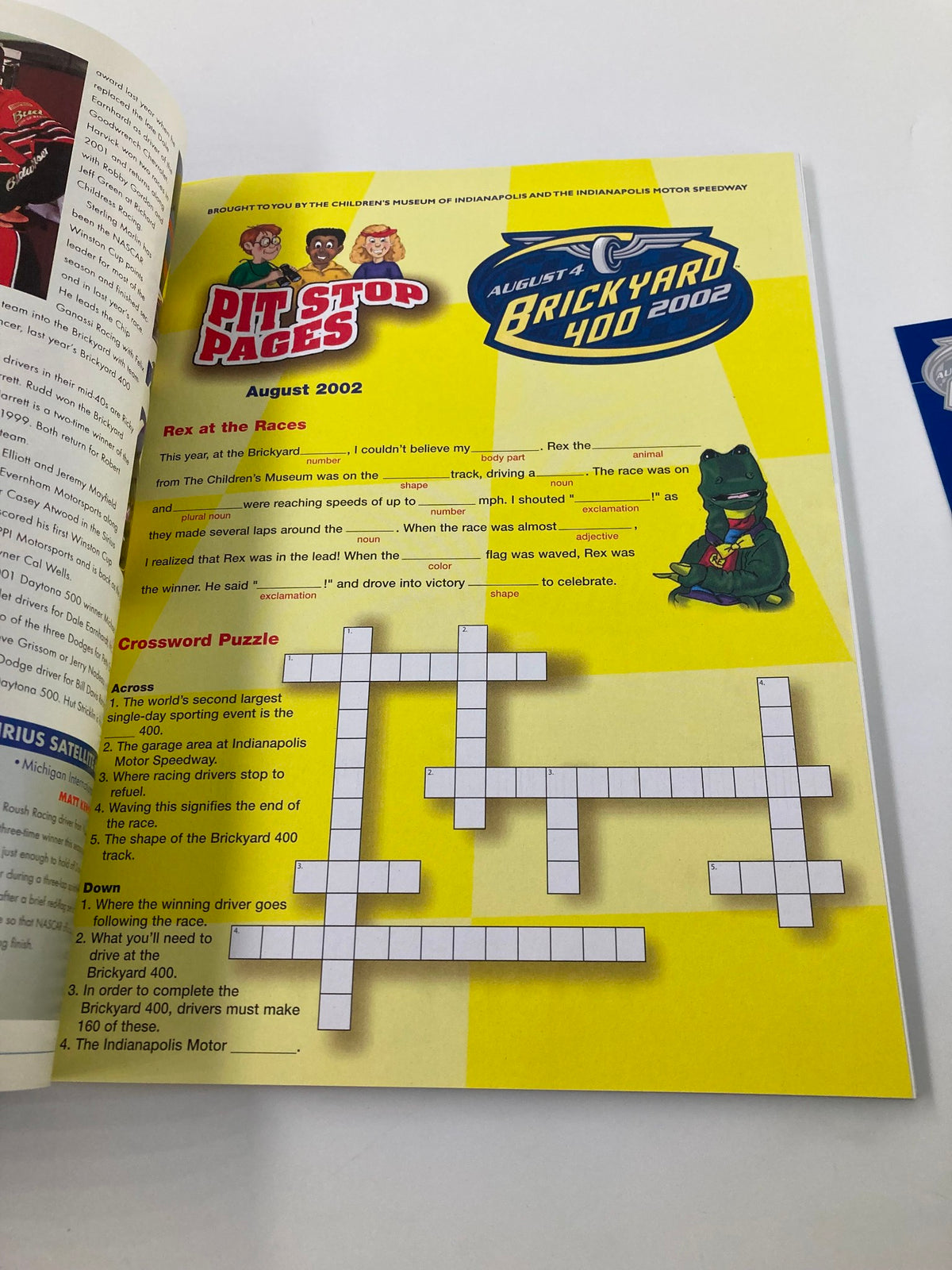 Page from August 4 2002 NASCAR Brickyard 400 Starting Field Official Program displaying a crossword puzzle and pit stop information.