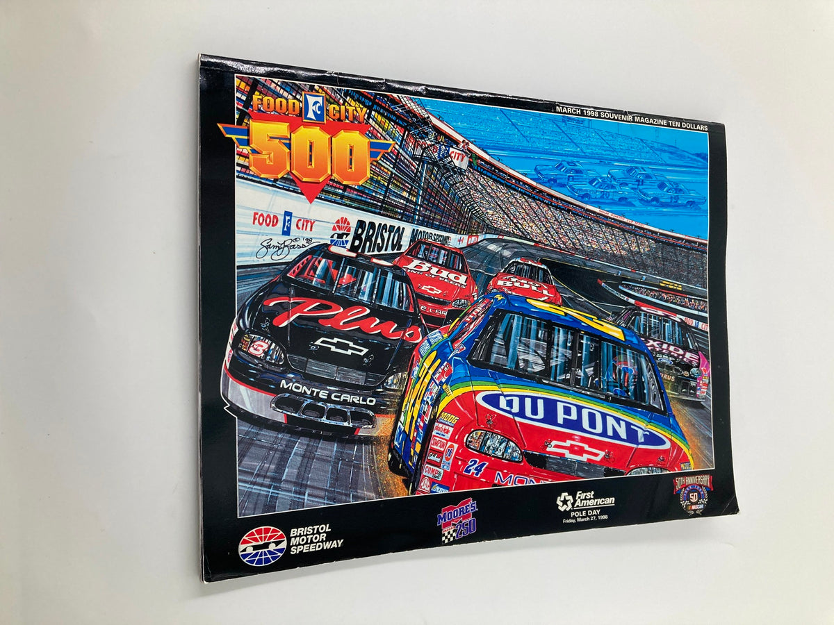 Side view of the March 1998 Food City 500 Bristol Motor Speedway Souvenir Magazine showing the vibrant illustration of NASCAR vehicles, a collectible for racing fans.