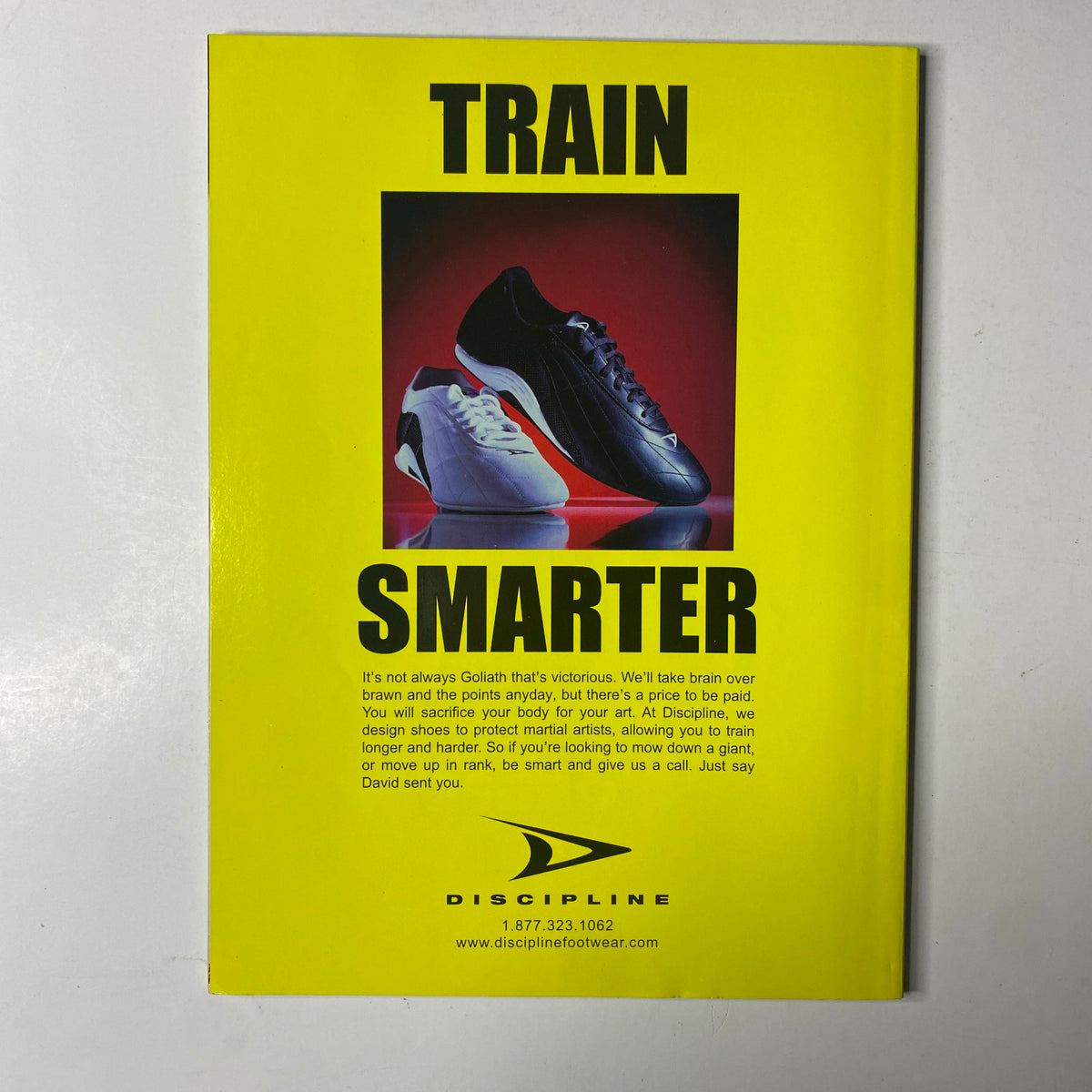 Inside Kung-Fu Magazine March 2003 promotional page for Discipline footwear, highlighting the message 'Train Smarter' with a visual of athletic shoes, relevant to martial arts training.