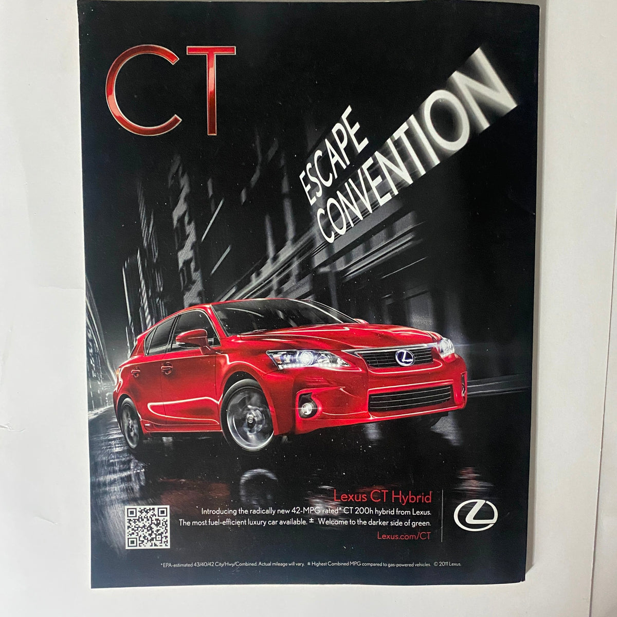 Advertisement for the Lexus CT Hybrid, featured in Interview Magazine April 2011, presenting a sleek red car with a modern design, highlighting its efficiency and innovative features.