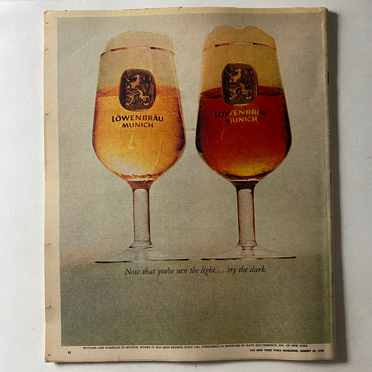 Vintage advertisement in The New York Times Magazine from August 23, 1970 featuring two Löwenbräu Munich beer glasses with the quote 'Now that you've seen the light... try the dark.'
