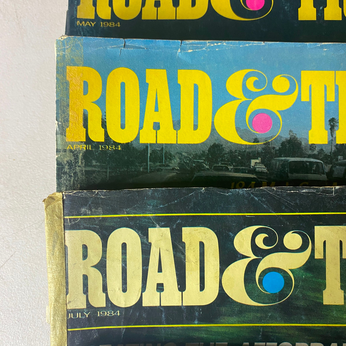 Close-up view of three Road & Track Magazine covers from April, May, and July 1984, highlighting the classic designs and featured automotive content.