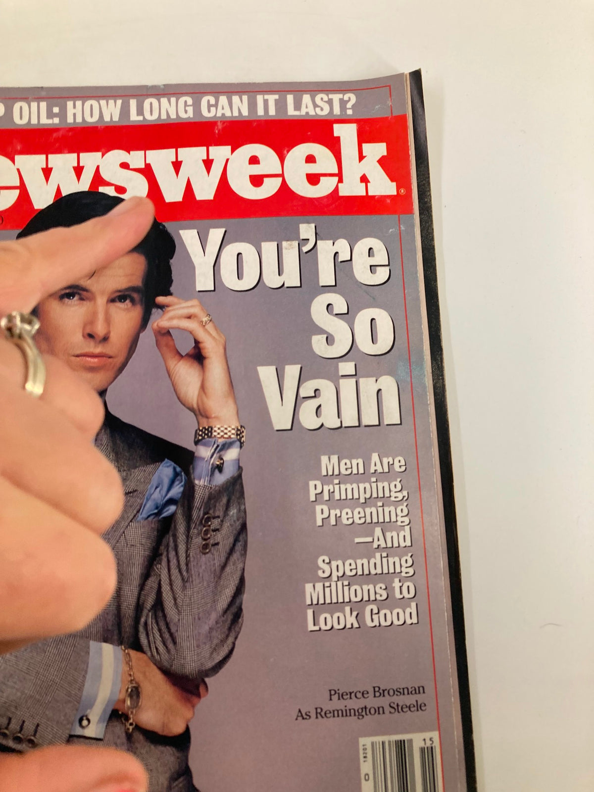 Close-up of the vintage Newsweek magazine cover from April 14, 1986, showcasing Pierce Brosnan as Remington Steele. The magazine highlights themes of men's grooming and includes the title 'You're So Vain'.