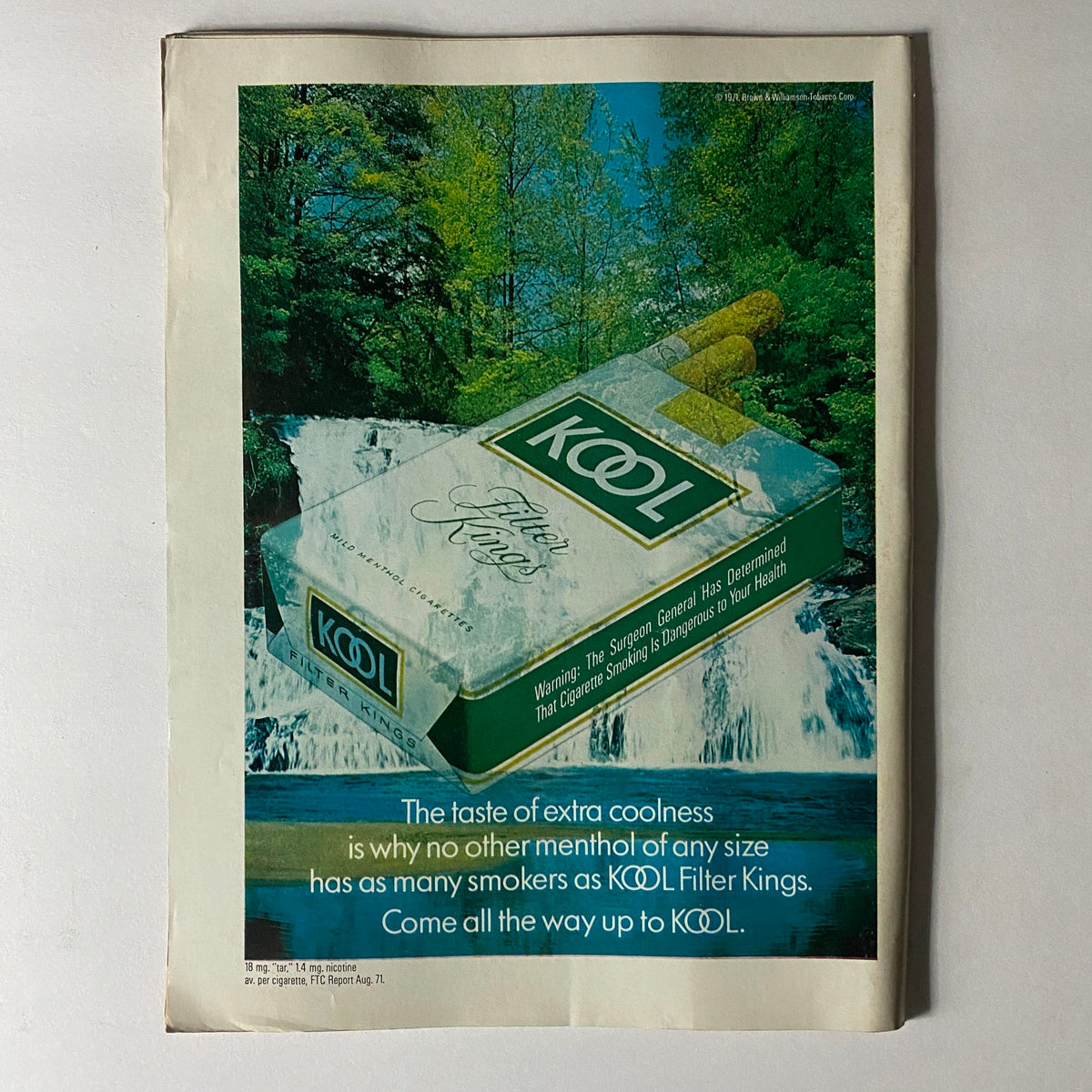 Vintage advertisement for KOOL Filter Kings cigarettes, highlighting the product's coolness against a scenic waterfall background.