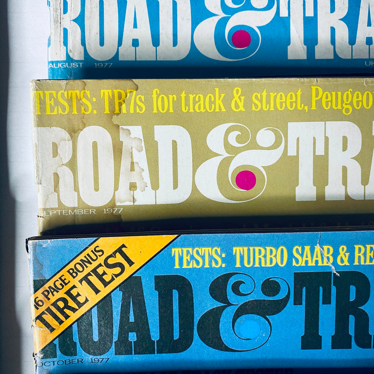 Lot of 10 Road & Track Magazine 1977 February, March, May, June, August-December displaying magazine covers from the August to October issues with automotive testing features.
