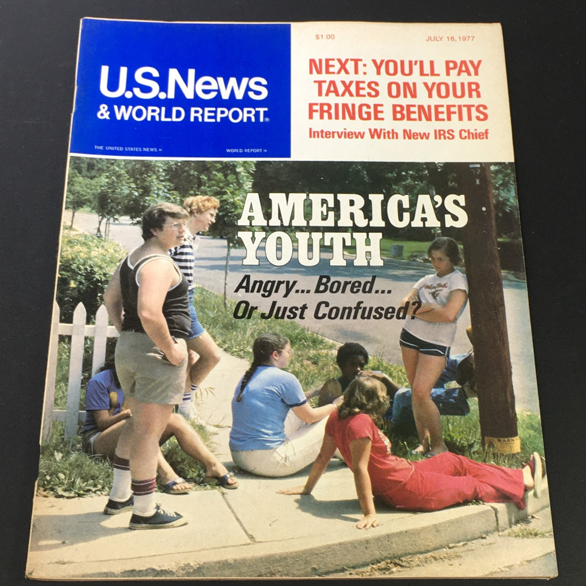 Cover of VTG US News & World Report from July 18, 1977 featuring the title 'America's Youth' with a focus on themes of youth culture and fringe benefits, showcasing a group of young people outdoors.