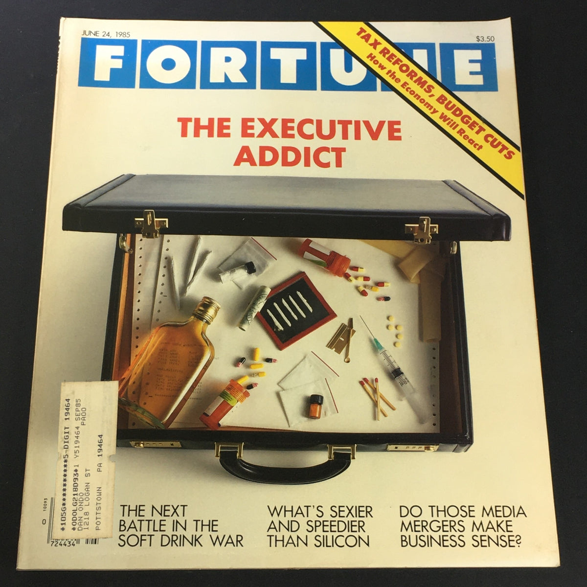 Cover of the VTG Fortune Magazine from June 24, 1985, titled 'The Executive Addict,' featuring an open briefcase with various items including a bottle, pills, and stationery. The cover highlights themes of tax reforms and budget cuts, with articles on business trends in the 1980s.