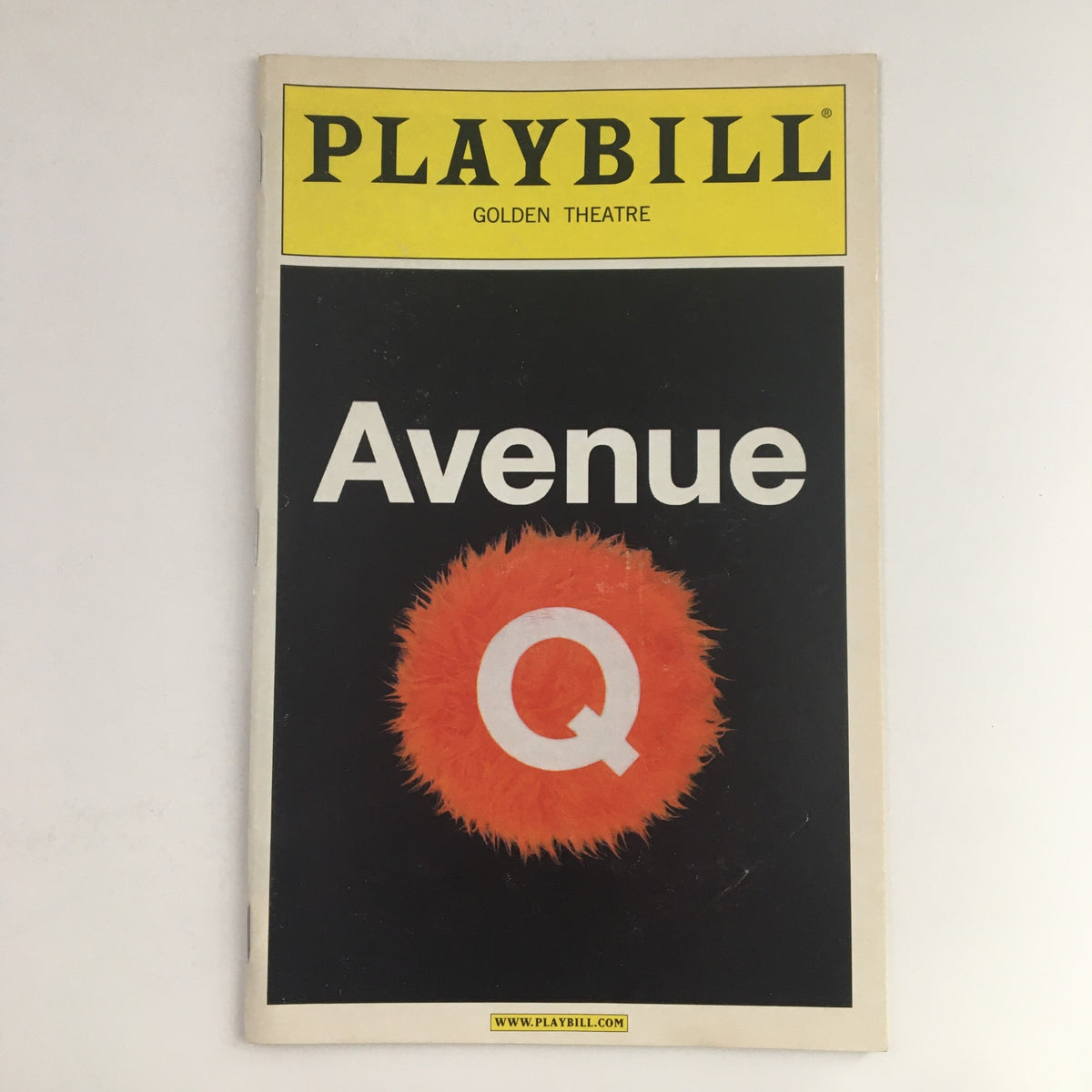 2004 Playbill for Avenue Q at the Golden Theatre, featuring the iconic bright orange 'Q' on a black background, presented by Kevin McCollum and directed by Jason Moore.