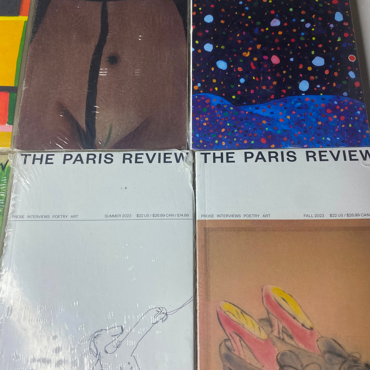 Detailed view of The Paris Review Magazine covers, highlighting the Summer and Fall 2022-2023 editions with artistic designs in brand new condition.