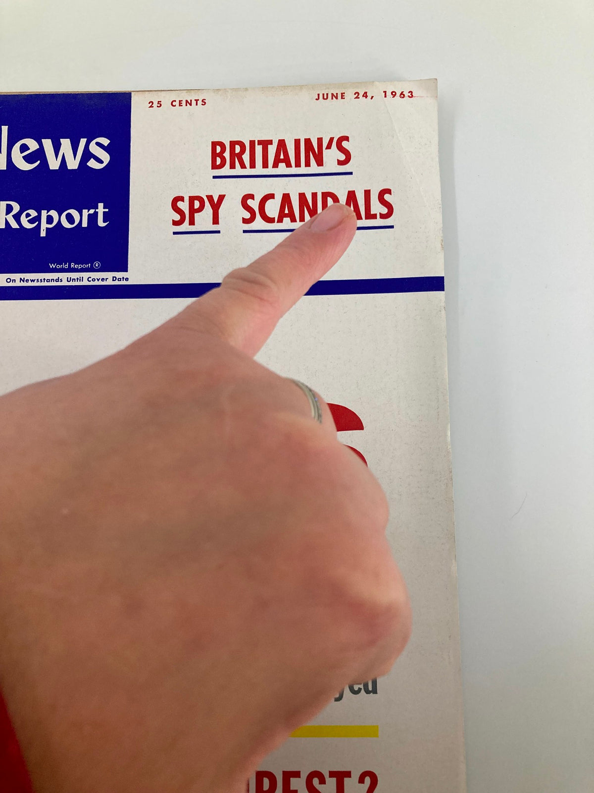 Close-up of the US News & World Report Magazine cover dated June 24, 1963, highlighting the section 'BRITAIN'S SPY SCANDALS' with a finger pointing at the text.