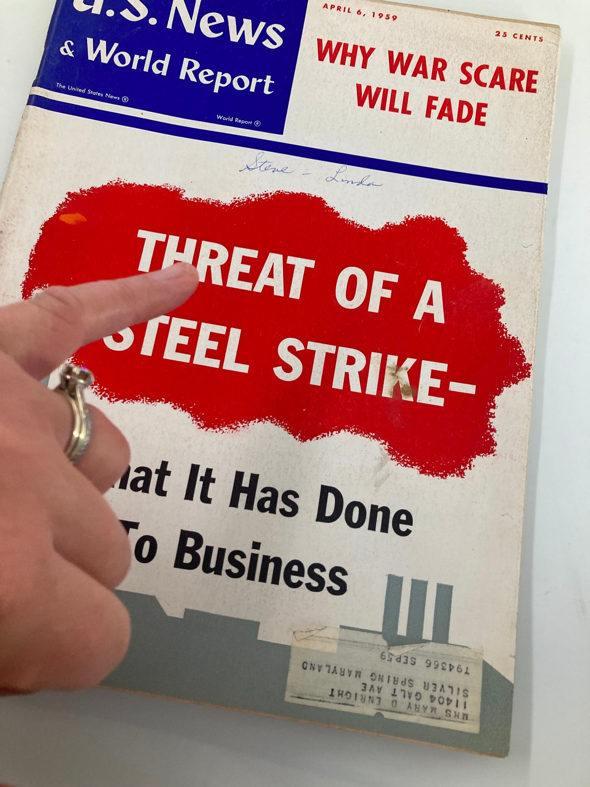 Detail of the cover of US News & World Report Magazine from April 6, 1959, highlighting the title 'Why War Scare Will Fade?' and the headline 'Threat of a Steel Strike - What It Has Done to Business'. A hand is pointing to the text, emphasizing the magazine's collectible features.