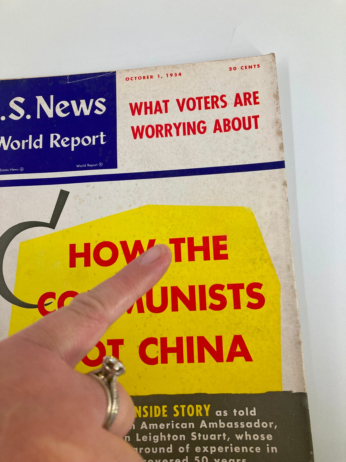 Detailed shot of the cover of US News & World Report Magazine, October 1, 1954, showing the title 'How The Communists Got China' with a finger pointing to the text.