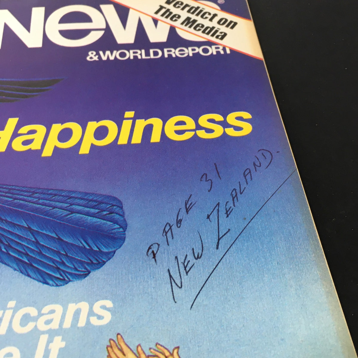 Close-up of the cover of VTG US News & World Report March 4 1985, highlighting the title 'Happiness' and a handwritten note about page 31 and New Zealand.