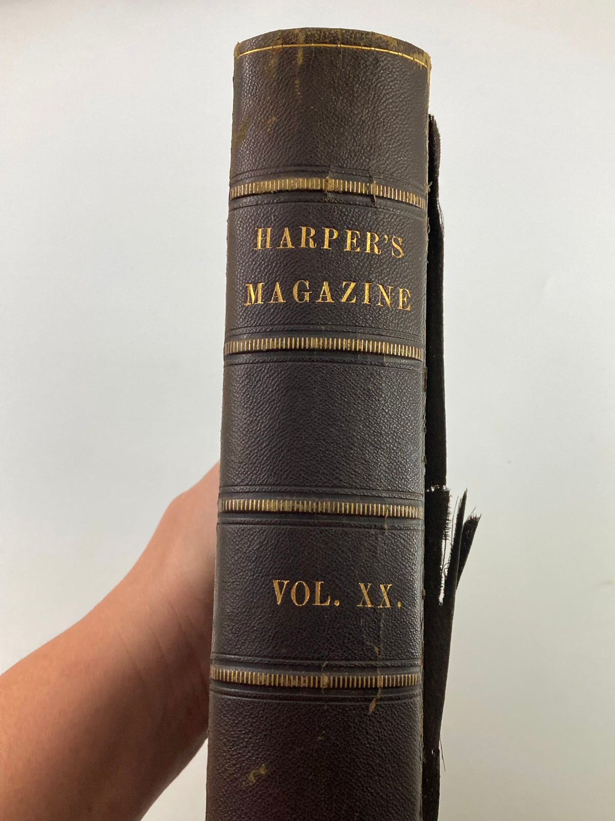 Side view of the VTG Harper's New Monthly Magazine Volume XX, featuring the title 'HARPER'S MAGAZINE VOL. XX.' in gold lettering on a worn leather spine.