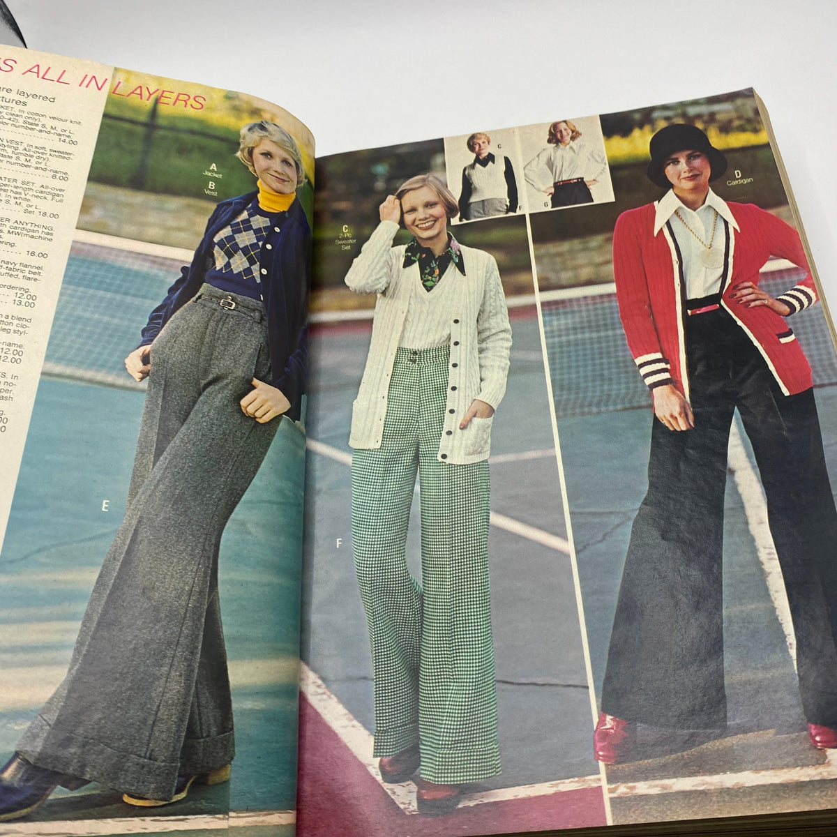 1973 JCPenney Fall and Winter All in Layers Catalog showcasing fashionable women's outfits, including a stylish cardigan and wide-leg trousers, set against a tennis court backdrop.