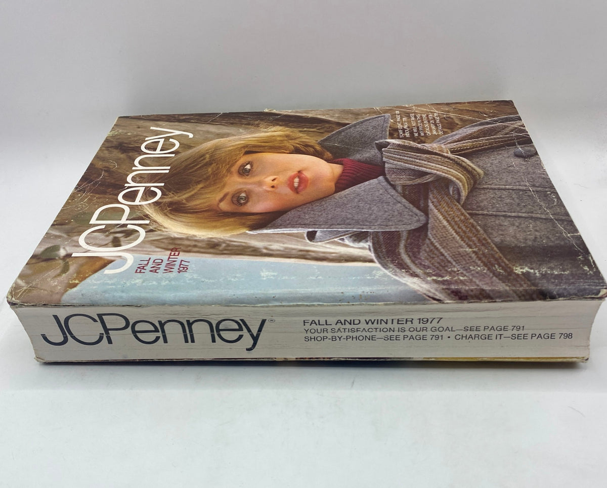 Side view of the 1977 JCPenney Fall and Winter Catalog, showing its worn cover and a close-up of the woman's face.