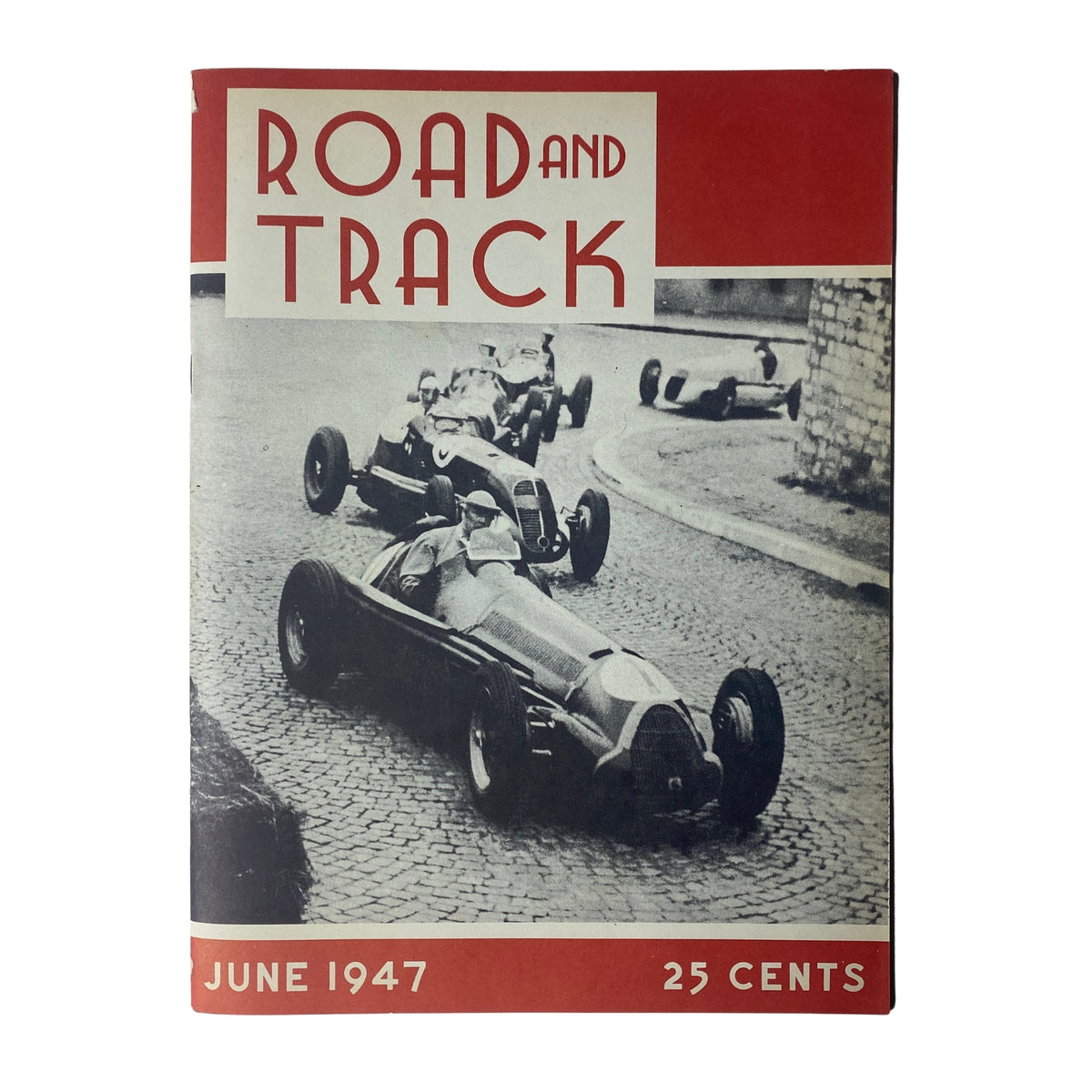 Cover of Road and Track Magazine June 1947 featuring vintage race cars on a cobblestone street, highlighting the premiere issue of this automotive publication.