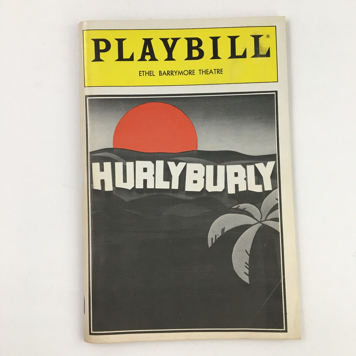 1984 Playbill for 'Hurly Burly' presented at Ethel Barrymore Theatre featuring a bold cover design with a red sun and palm trees.