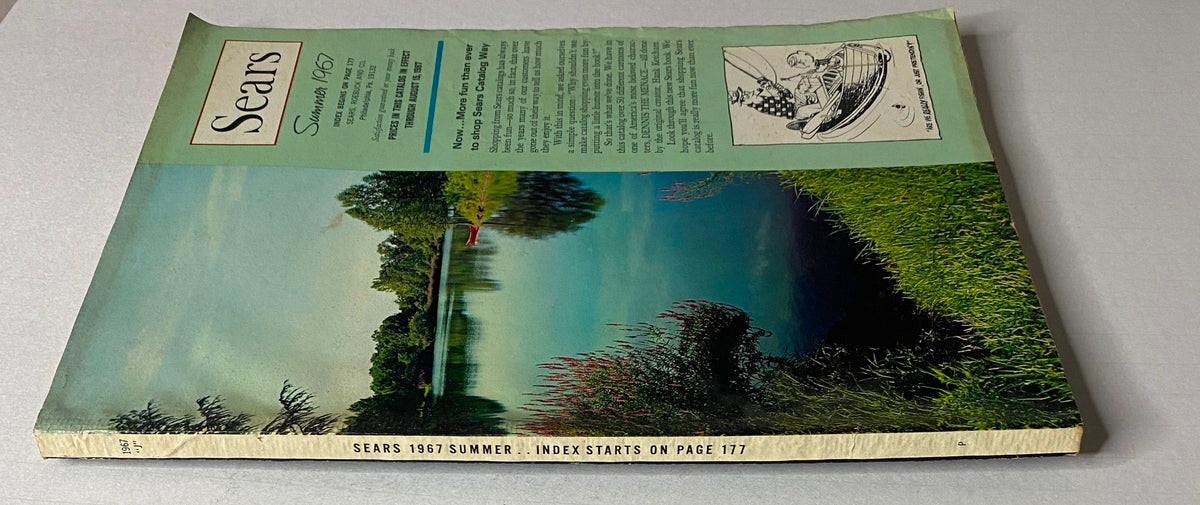 Side view of the 1967 Sears Summer Catalog showcasing its vibrant cover illustration of a lake and greenery, emphasizing the catalog's vintage appeal.