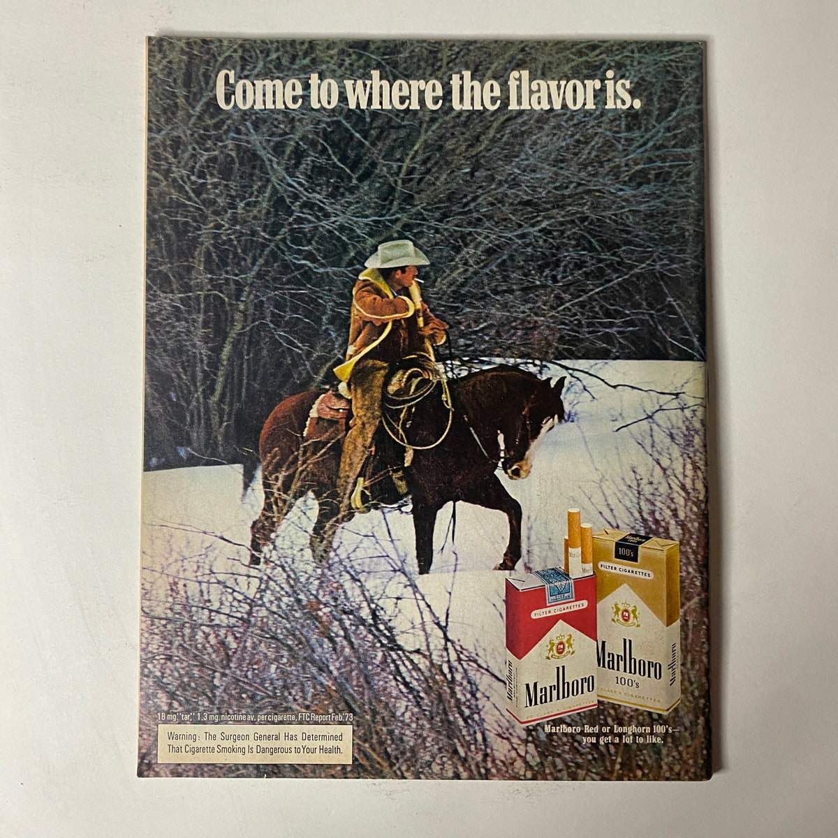 Vintage Marlboro advertisement featuring a cowboy on horseback, published in Car Craft Magazine December 1973, promoting tobacco products amidst classic Americana.