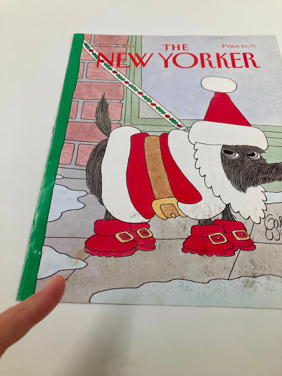 Close-up view of The New Yorker December 9, 1991 cover, highlighting the Christmas dog by Gahan Wilson dressed in festive attire, including a Santa hat and boots.