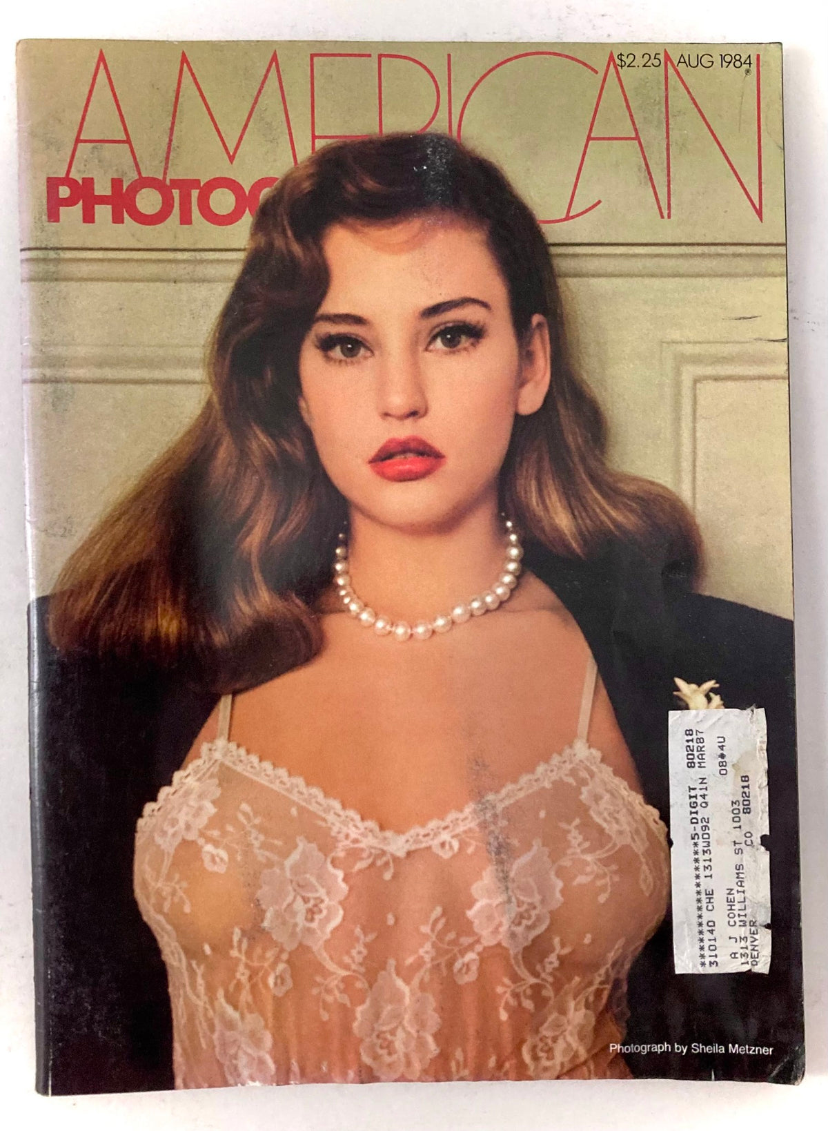 American Photographer Magazine August 1984 cover featuring Jill Goodacre, showcasing the model in a lace outfit with a pearl necklace, capturing the essence of 1980s fashion.