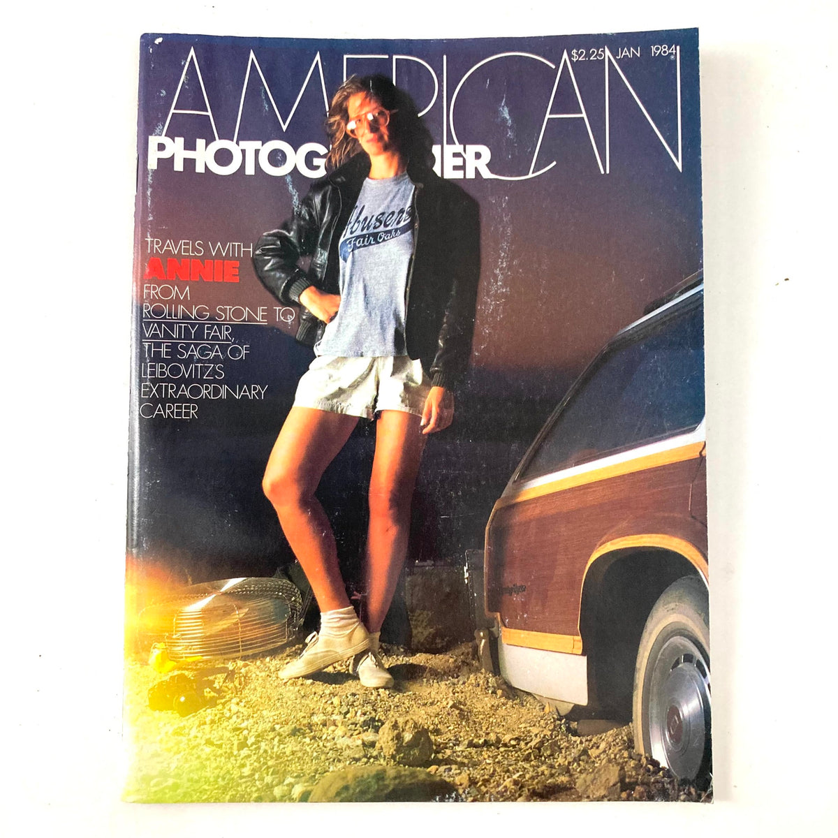 Cover of American Photographer Magazine January 1984 featuring a model wearing a leather jacket and sunglasses, with the title and text highlighting travels with Annie Leibovitz and her career.