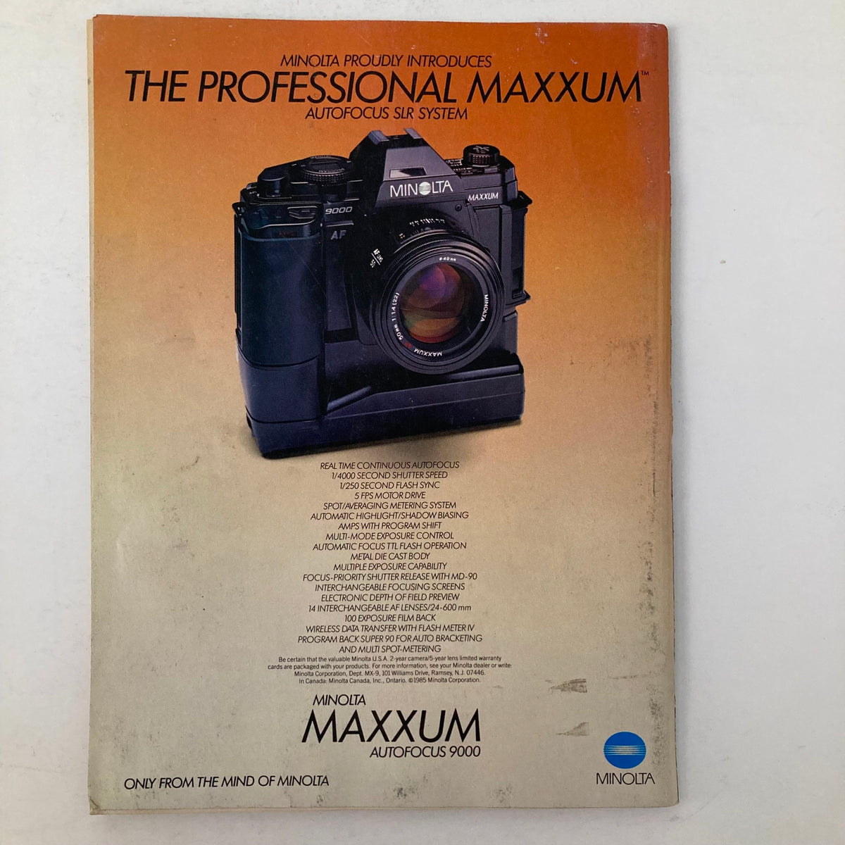 Advertisement for Minolta's Maxxum Autofocus SLR system from the November 1985 issue of American Photographer Magazine, highlighting the features of the camera.