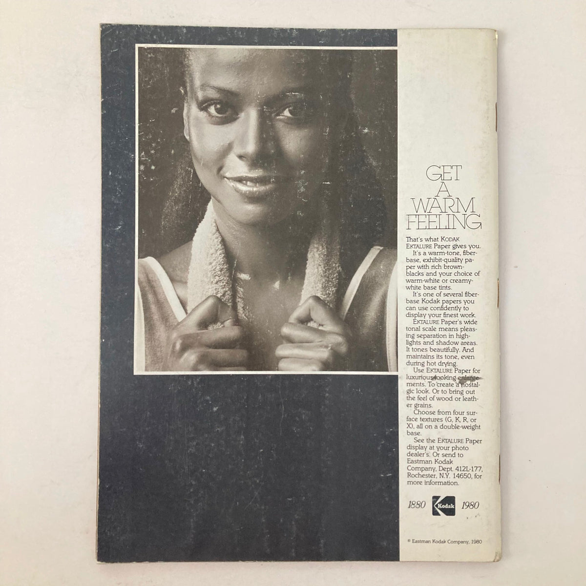Back cover of American Photographer Magazine December 1980 with an advertisement featuring a smiling woman holding a towel, promoting Kodak Extralife Paper.