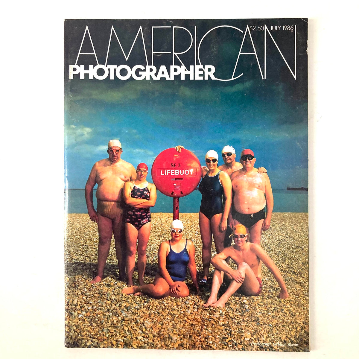 Cover of American Photographer Magazine July 1986 featuring members of the Channel Swimming Association at a beach with a lifebuoy.