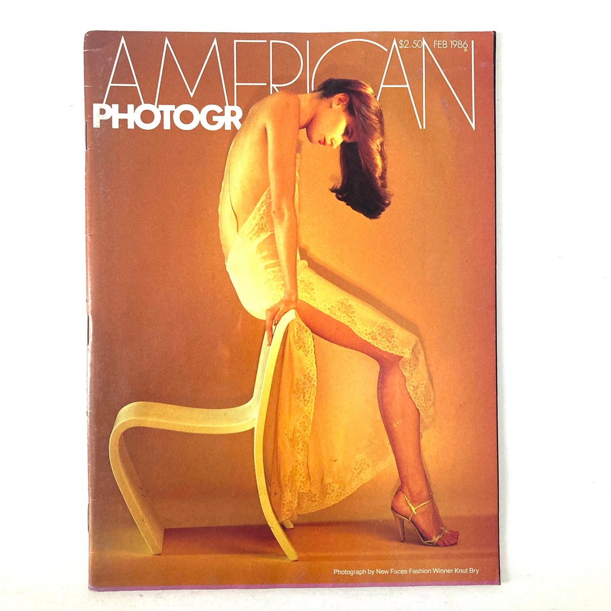 Cover of American Photographer Magazine February 1986 featuring a model wearing a lace dress, photographed by New Faces Fashion Winner Knut Bry.