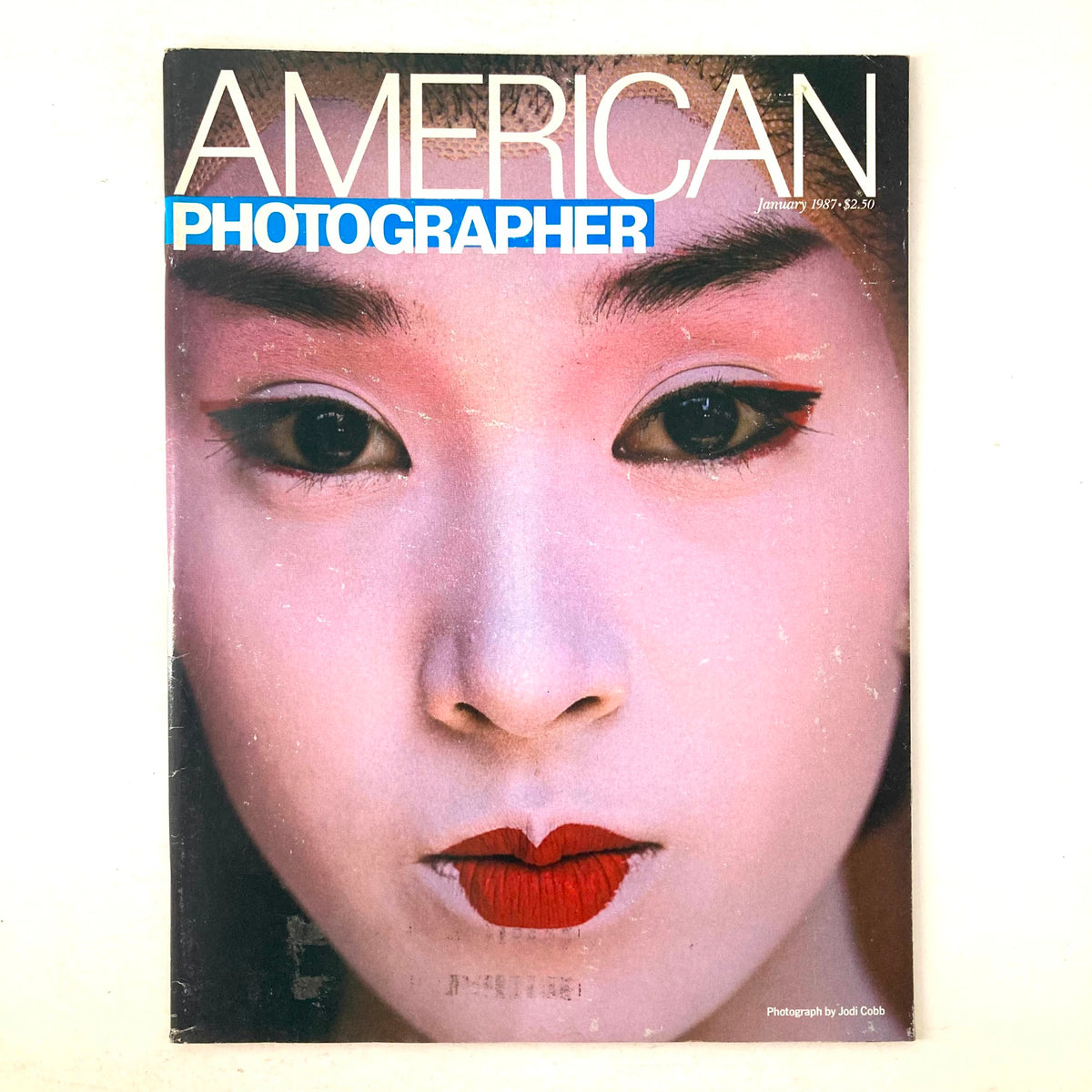 Cover of American Photographer Magazine January 1987 featuring a striking portrait of a Geisha with traditional makeup, illustrating Japanese culture and artistry.