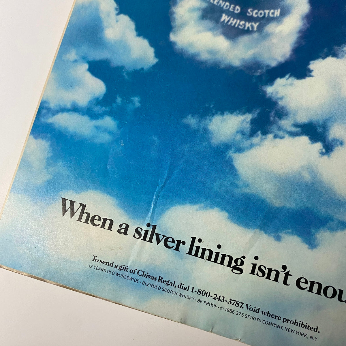 Close-up view of the back cover advertisement for Chivas Regal blended Scotch whisky from Forbes Magazine September 22, 1986, featuring clouds and the text 'When a silver lining isn't enough.'