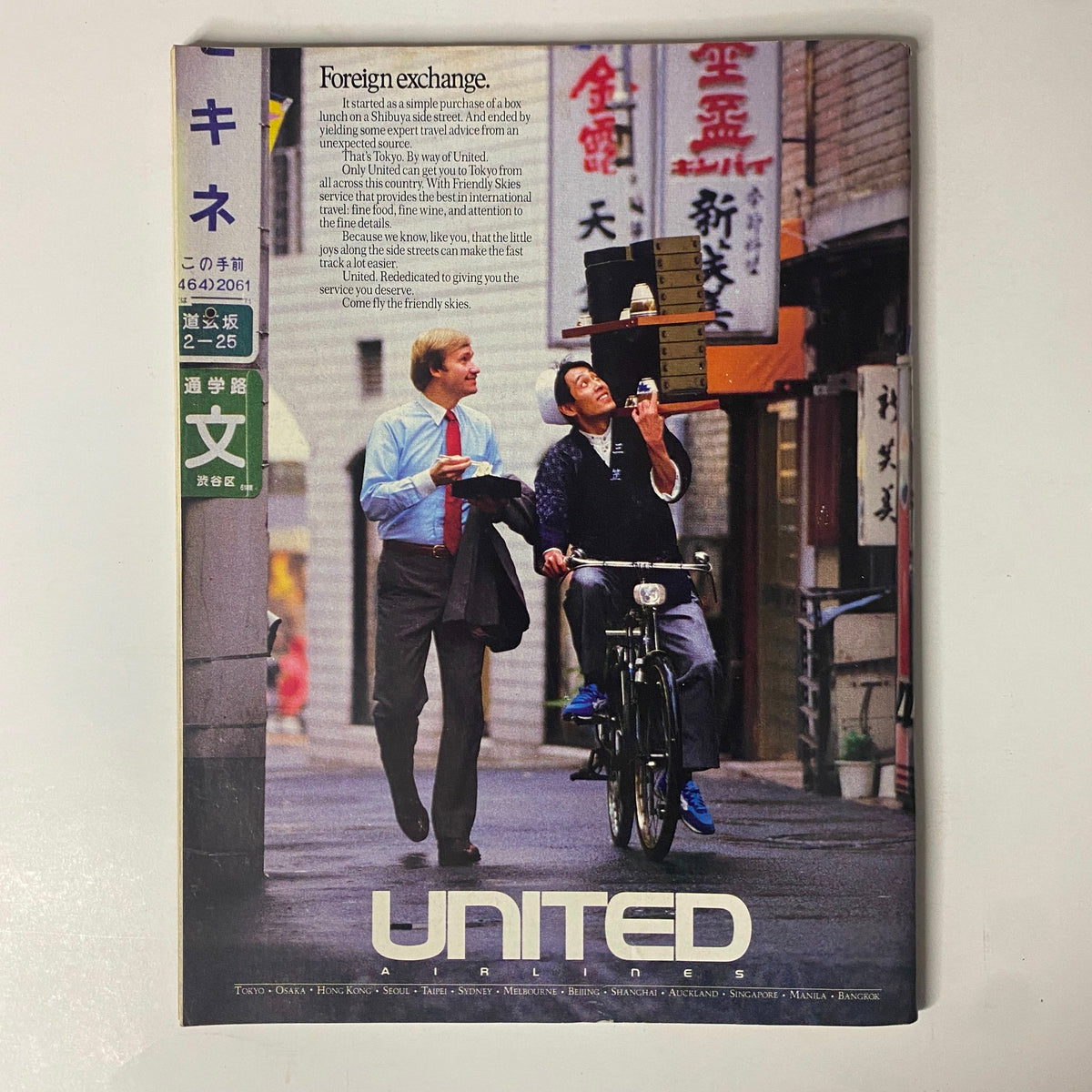 Cover page of United Airlines advertisement in Forbes Magazine October 17, 1988, depicting a friendly interaction in Tokyo, symbolizing international travel.
