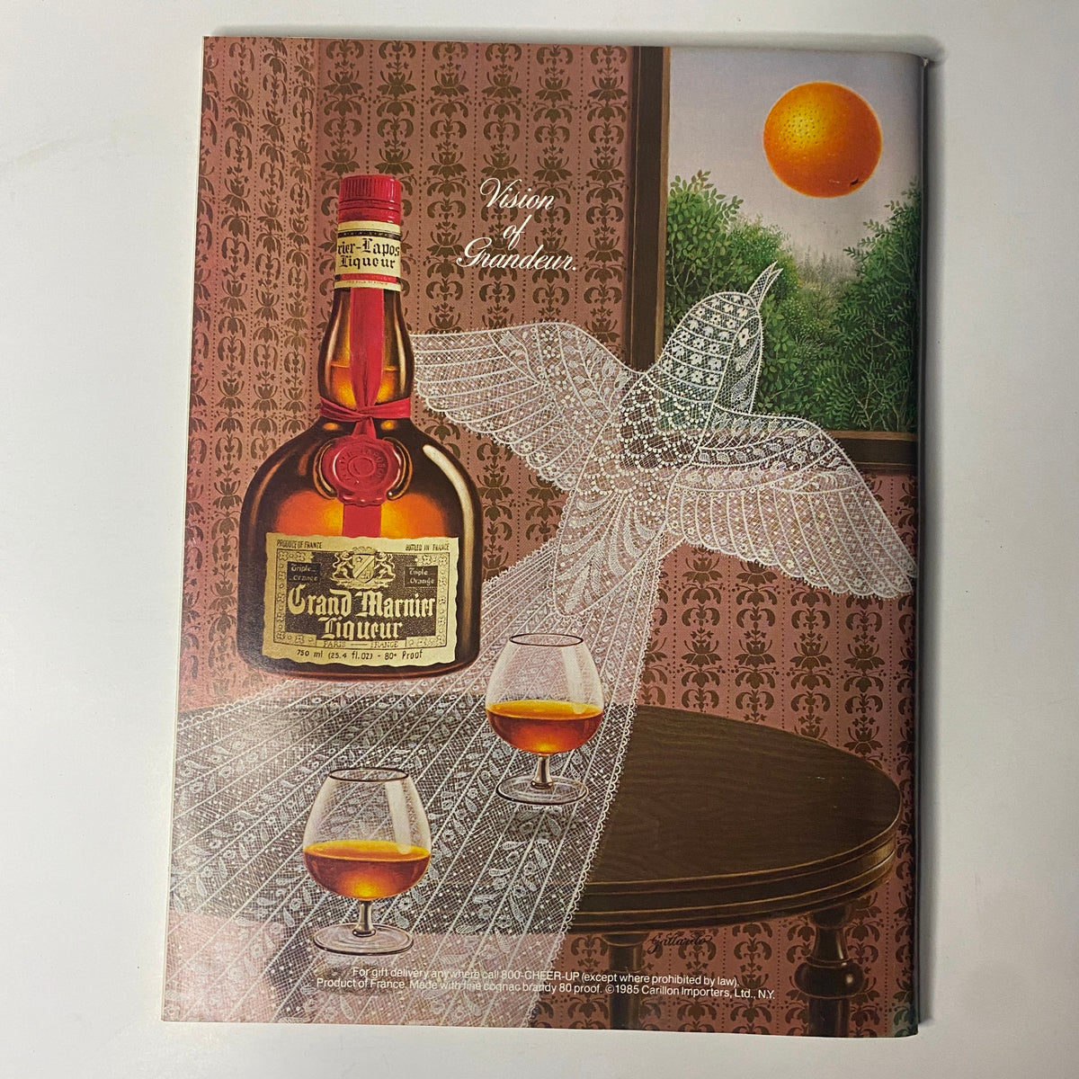 An advertisement for Grand Marnier liqueur featured in Forbes Magazine dated October 7, 1985, showcasing the bottle and a decorative design.