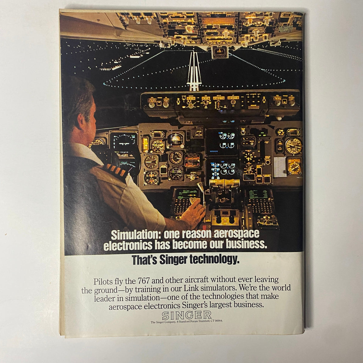 Forbes Magazine February 10, 1986, showcasing a full-page advertisement for Singer technology, illustrating a pilot in an aircraft cockpit, emphasizing the role of simulation in aerospace electronics.