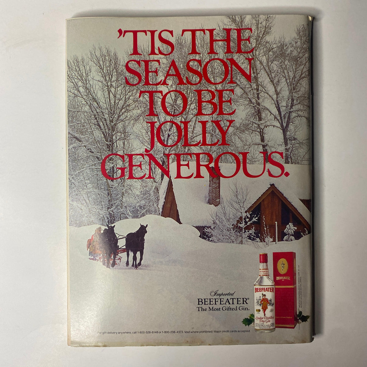 'Tis the season to be jolly generous advertisement from Forbes Magazine November 18, 1985 featuring holiday imagery and a Beefeater Gin advertisement.