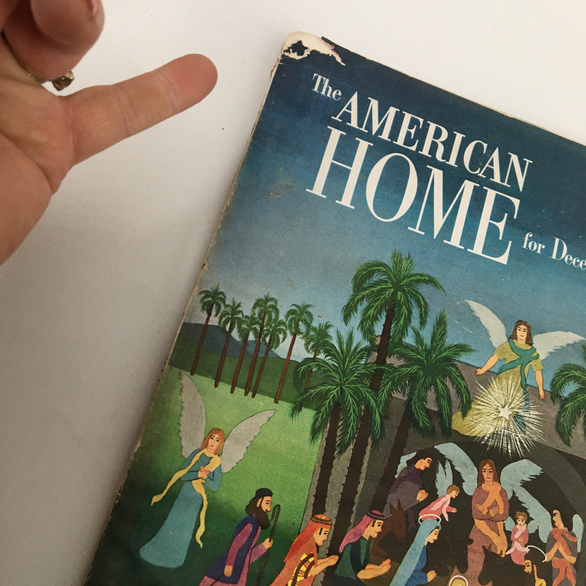 Close-up of the cover of VTG The American Home Magazine December 1950, showing details of the illustrated characters and palm trees, highlighting its vintage appeal.