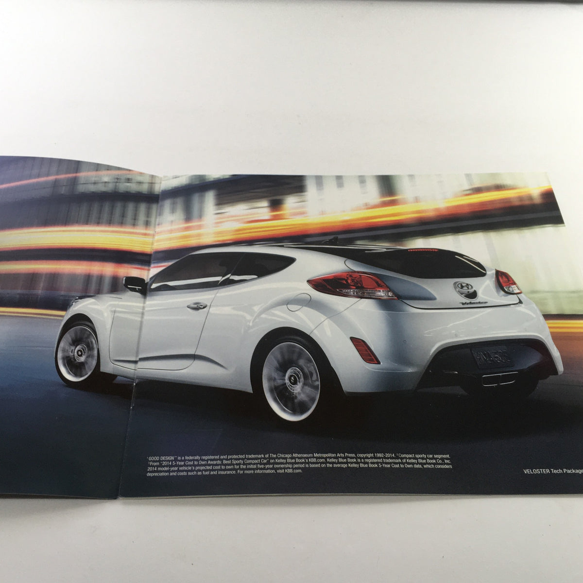 Interior view of the 2015 Hyundai Veloster Dealership Car Auto Brochure Catalog featuring the car's rear design in motion.