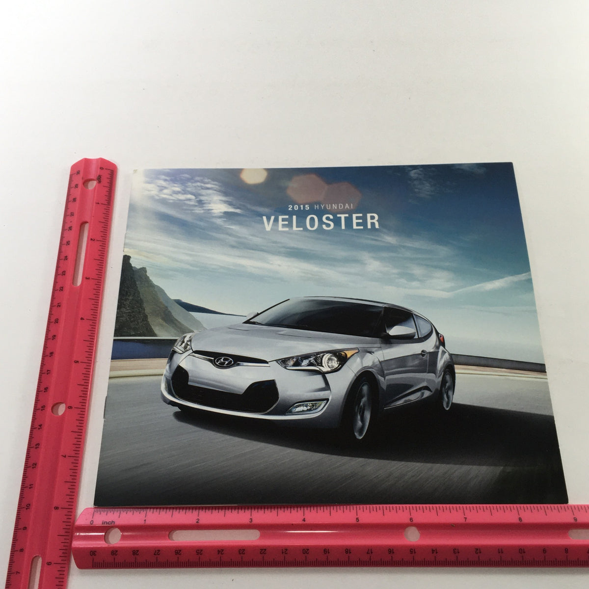Front cover of the 2015 Hyundai Veloster Dealership Car Auto Brochure Catalog featuring a sleek silver Hyundai Veloster against a scenic backdrop.